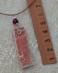 Clay pendant in red iridescent shades