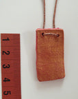 Handmade red-gold clay pendant