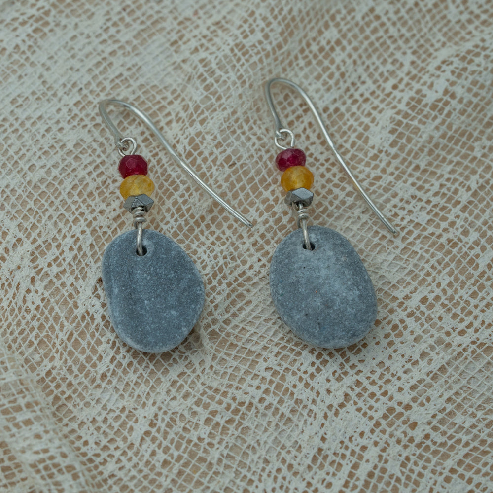 Handmade earrings with smooth gray pebbles, accented with red and yellow agate beads on silver hooks.