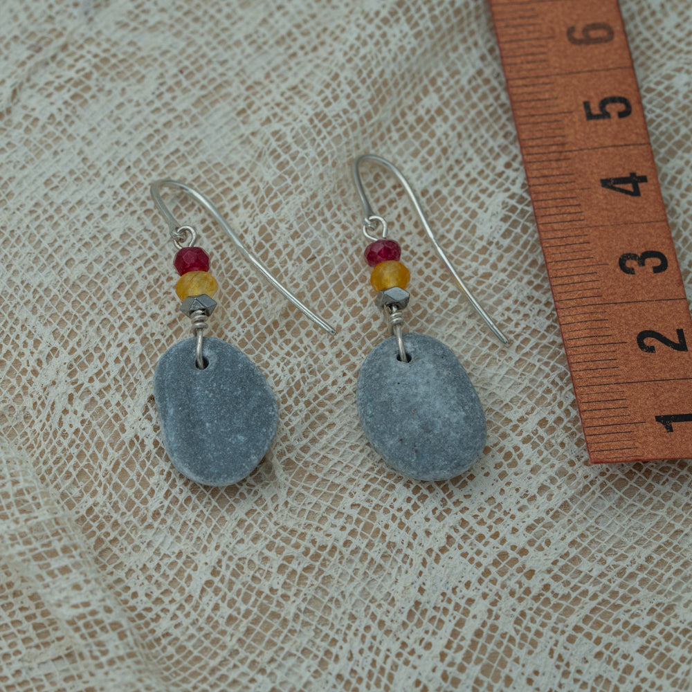 Handmade earrings with smooth gray pebbles, accented with red and yellow agate beads on silver hooks.