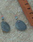 Handmade earrings with smooth gray pebbles, accented with pink agate and hematite beads on silver hooks