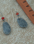 Handmade earrings with smooth gray pebbles, accented with red agate and hematite beads on silver hooks.